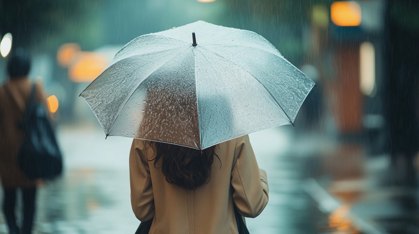 person holding an umbrella in the rain, symbolizing extra insurance coverage and protection