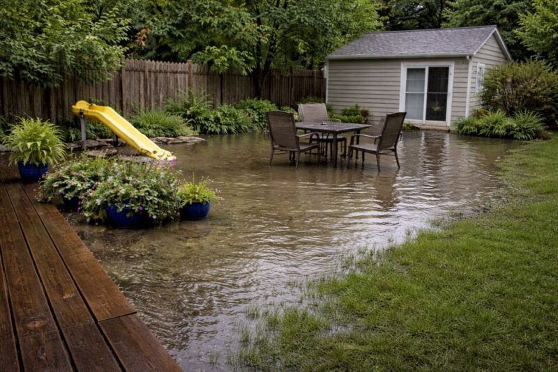 Backyard flooded with standing water reaching patio and lawn area