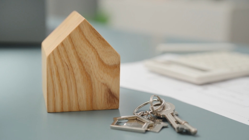 House model and keys on a desk representing property secured by debt such as a mortgage