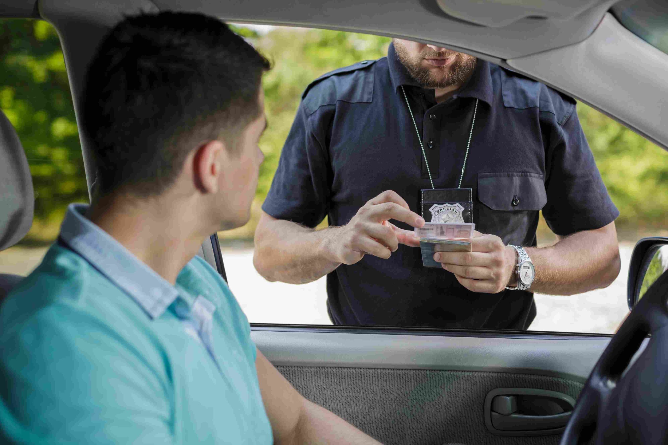 Driver handing identification to a police officer during a traffic stop
