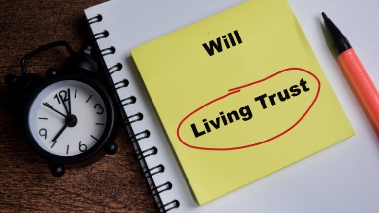 Notebook with the words “Will” and “Living Trust” written on a note, illustrating the difference between a will and a living trust